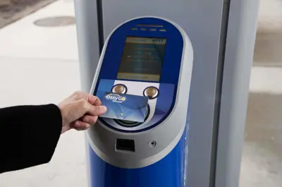hand tapping an EasyGO fare card on a fare vending machine