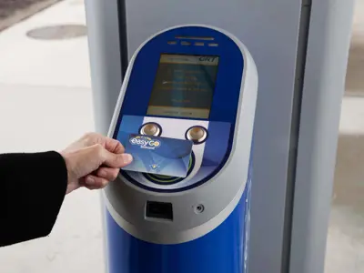 hand tapping an EasyGO fare card on a fare vending machine